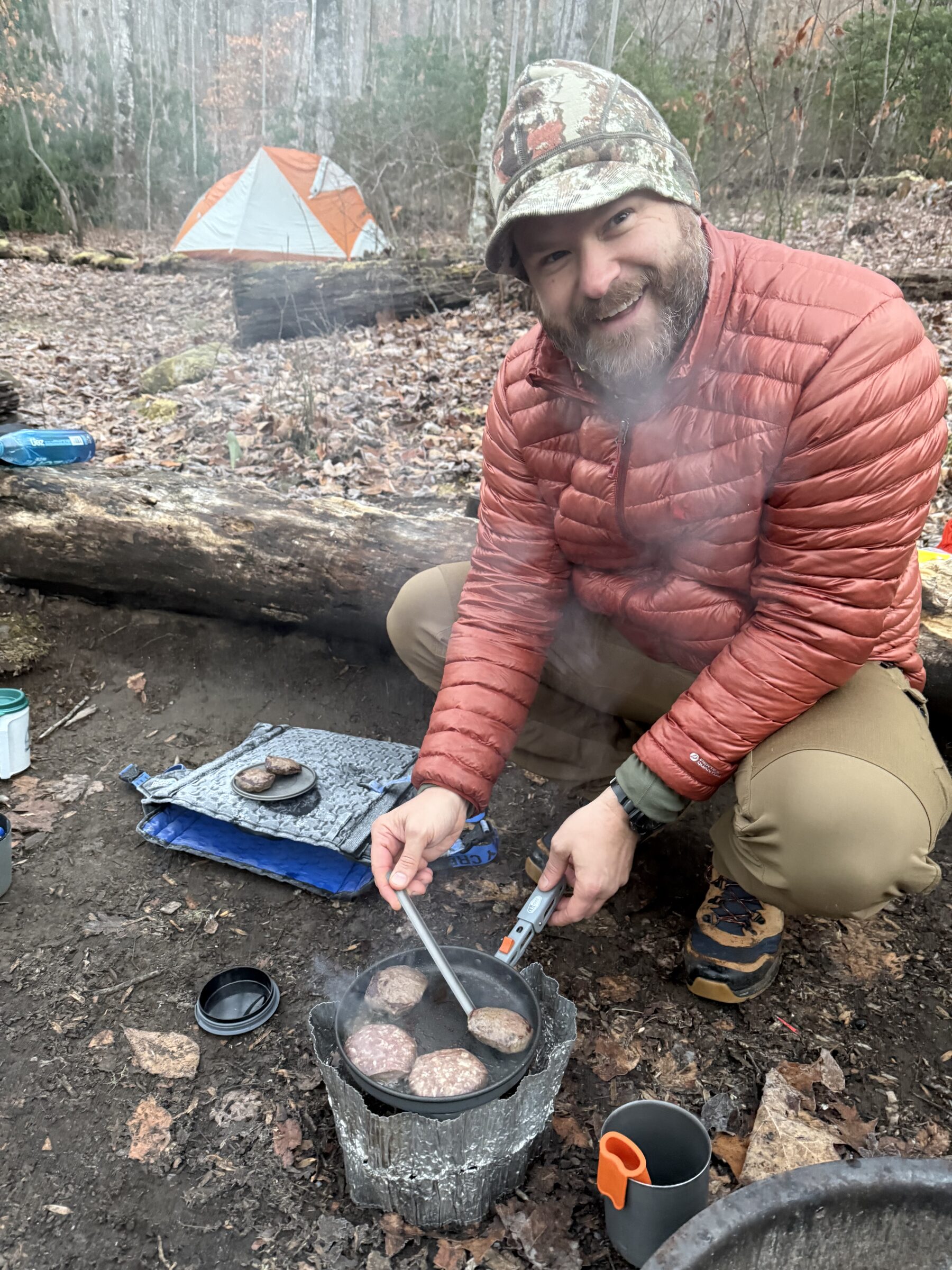 Coach Hugh cooking venison sausage for breakfast on a freezing morning in Great Smoky Mountains National Park